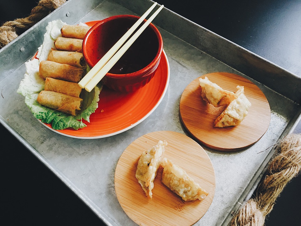 A picture of potstickers and egg rolls are shown