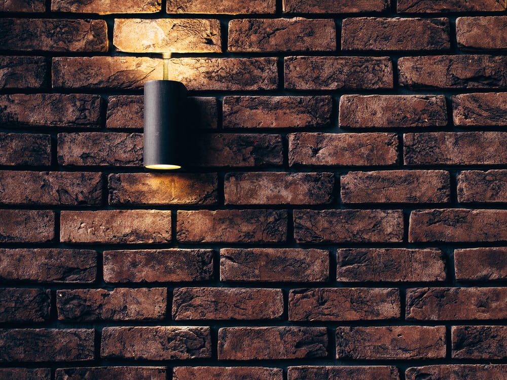 A picture of a subtle downlighting cast over a brick wall