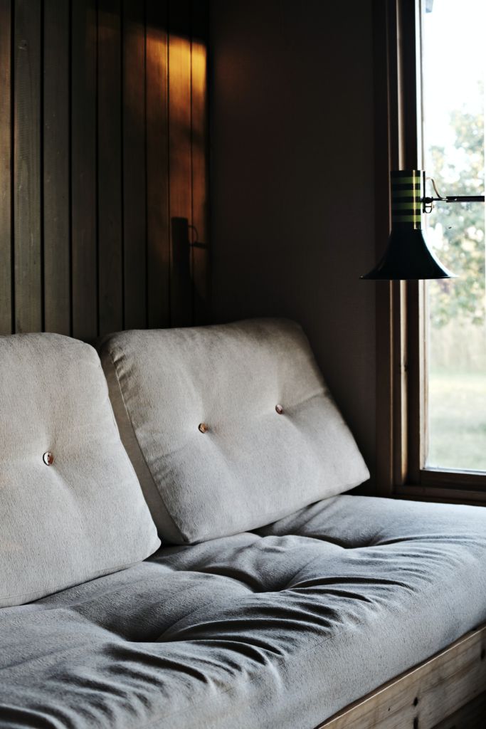 A picture of a couch with slight lighting emanating from a window