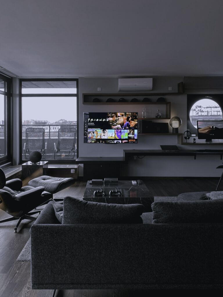 A picture of a mounted TV with hidden speakers which is just one many examples of hiding home theater equipment.