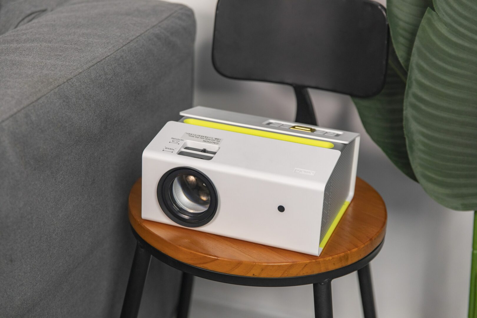 A projector sitting on a table with a remote calibrating for display color shift
